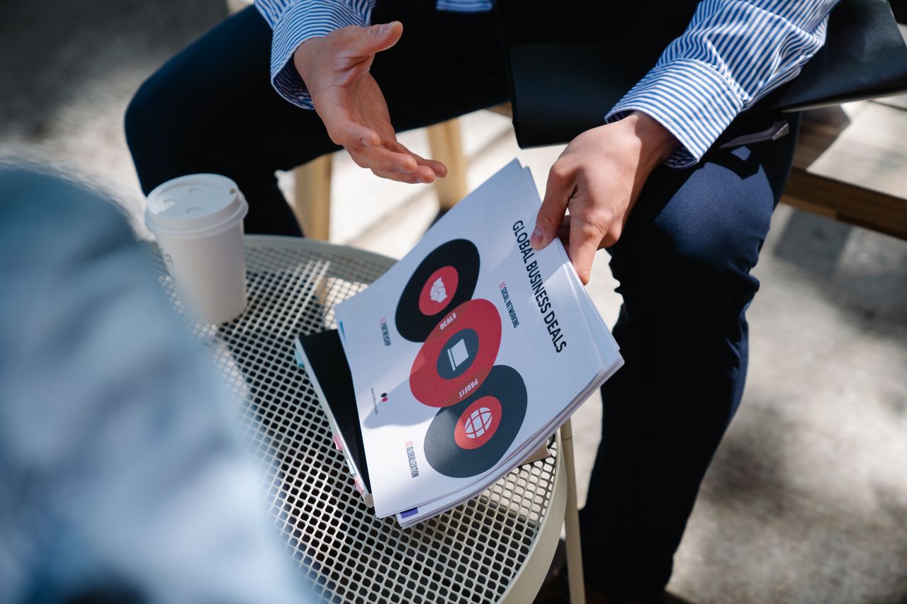 Services A businessman discusses global business deals with visual aids during an outdoor meeting.